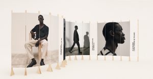 Scénographie de vitrine pour Devred avec panneaux courbes imprimés, structures en bois clair et visuels de mannequins dans une mise en scène épurée